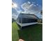 Side view of a home featuring a screened-in porch, nice green grass and sunny skies at 1005 Matthew Ave, Lady Lake, FL 32159