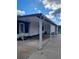 Exterior view of home with a carport, white columns, white door, and lush green grass around the home at 1005 Matthew Ave, Lady Lake, FL 32159