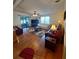 Cozy living room featuring hardwood floors, comfortable seating, and a sliding glass door to the sun room at 1005 Matthew Ave, Lady Lake, FL 32159