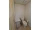 Toilet room with a cabinet for storage and patterned wallpaper at 1005 Matthew Ave, Lady Lake, FL 32159