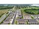 Aerial view showing a residential neighborhood featuring townhomes, manicured lawns, and nearby lake at 1042 Lido Dr, Howey In The Hills, FL 34737