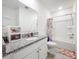 Bright bathroom features a granite-topped vanity, framed mirror, and a shower-tub combo at 1042 Lido Dr, Howey In The Hills, FL 34737