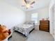 Bedroom featuring carpet, a ceiling fan, a bed, and a dresser next to a window at 1042 Lido Dr, Howey In The Hills, FL 34737