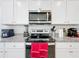 Modern kitchen featuring stainless steel appliances, white cabinets, and granite countertops at 1042 Lido Dr, Howey In The Hills, FL 34737