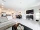 Open-concept layout featuring tile flooring, a large TV, and a kitchen area with an island, ideal for modern living at 1042 Lido Dr, Howey In The Hills, FL 34737