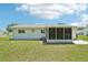 Lush backyard features a well-maintained lawn and partial view of home and screened-in porch at 11214 Sw 77Th Ct, Ocala, FL 34476