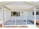Charming front porch with white railing, seating, and a clear view of the street at 11214 Sw 77Th Ct, Ocala, FL 34476