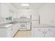 Bright eat-in kitchen features white cabinetry, tile flooring, and modern appliances at 11214 Sw 77Th Ct, Ocala, FL 34476