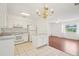 Bright eat-in kitchen flows to living room with white cabinetry and tile flooring at 11214 Sw 77Th Ct, Ocala, FL 34476