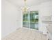 Bright eat-in kitchen with white cabinetry, modern appliances, and tile flooring with a view to enclosed lanai at 11214 Sw 77Th Ct, Ocala, FL 34476