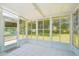 Bright sunroom with tiled floor, multiple windows offering outdoor views, and access to the backyard at 11214 Sw 77Th Ct, Ocala, FL 34476