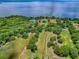 Aerial view of lakefront property showing the property lines surrounded by mature trees and a sprawling lawn at 11226 Lane Park Rd, Tavares, FL 32778
