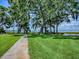 Expansive backyard featuring lush green grass and mature trees with views of the serene lake at 11226 Lane Park Rd, Tavares, FL 32778