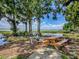 Scenic lakefront property featuring a wooden picnic table and views of the serene lake and surrounding nature at 11226 Lane Park Rd, Tavares, FL 32778