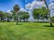 Expansive backyard featuring a large grassy area with mature trees and waterfront views at 11226 Lane Park Rd, Tavares, FL 32778
