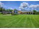 Expansive backyard with lush green lawn, well-maintained landscaping, and a charming pergola at 11226 Lane Park Rd, Tavares, FL 32778