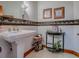 Charming bathroom with decorative tile accent and modern fixtures, featuring a unique pedestal sink at 11226 Lane Park Rd, Tavares, FL 32778