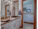 Elegant bathroom with marble countertop vanity, large decorative mirror, and private toilet area at 11226 Lane Park Rd, Tavares, FL 32778