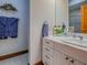 Bathroom featuring a white vanity with a marble countertop and modern fixtures, complemented by blue hand towels at 11226 Lane Park Rd, Tavares, FL 32778
