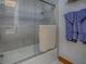 Bathroom featuring a glass enclosed shower and tub, complemented by modern fixtures and blue hand towels at 11226 Lane Park Rd, Tavares, FL 32778