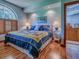 A cozy bedroom with an arched window, a quilt-covered bed, and an en-suite bathroom at 11226 Lane Park Rd, Tavares, FL 32778