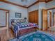 Cozy bedroom with wood floors, a quilt-covered bed, closet, and en-suite bathroom at 11226 Lane Park Rd, Tavares, FL 32778
