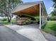 Well-maintained carport with space for RV, a wooden beam ceiling, and convenient driveway access at 11226 Lane Park Rd, Tavares, FL 32778