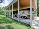 Large RV under the cover of a carport with wooden beam ceiling at 11226 Lane Park Rd, Tavares, FL 32778