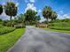 Long driveway leading to a gated entrance surrounded by lush landscaping at 11226 Lane Park Rd, Tavares, FL 32778