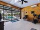 Bright exercise room with wood paneling, skylight and sliding glass doors to outdoor swimming pool at 11226 Lane Park Rd, Tavares, FL 32778
