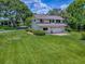 This two-story home with an attached garage is surrounded by a well-maintained lawn and mature trees at 11226 Lane Park Rd, Tavares, FL 32778
