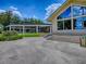 Home exterior with expansive glass windows showcasing the bright and airy interior, complemented by a screened-in lanai at 11226 Lane Park Rd, Tavares, FL 32778