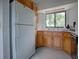 Cozy kitchen with oak cabinets, white appliances, and a window over the sink at 11226 Lane Park Rd, Tavares, FL 32778