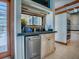 Kitchen nook features granite countertops, stainless steel dishwasher, tile floor, and a view to the pool area at 11226 Lane Park Rd, Tavares, FL 32778