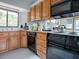A functional kitchen features wood cabinets, black appliances, and a window for natural light at 11226 Lane Park Rd, Tavares, FL 32778