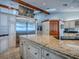 Gourmet kitchen features granite countertops, stainless steel refrigerator, tile floor, and stone accents at 11226 Lane Park Rd, Tavares, FL 32778