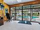 Home office with wood paneling, skylight and glass doors offering expansive views of the pool and patio at 11226 Lane Park Rd, Tavares, FL 32778