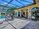 Covered patio with comfortable seating overlooking the enclosed pool area, perfect for entertaining guests at 11226 Lane Park Rd, Tavares, FL 32778