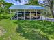 Large recreational vehicle stored under a shelter with a lush green lawn at 11226 Lane Park Rd, Tavares, FL 32778