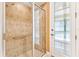 Bathroom featuring a walk-in shower with glass doors and a decorative exterior door, maximizing light at 1123 Barnacle Ter, The Villages, FL 32162
