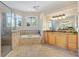 Bright bathroom showcasing a soaking tub, walk-in shower, and dual sink vanity with natural light at 1123 Barnacle Ter, The Villages, FL 32162
