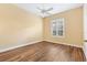 Bedroom with wood floors, neutral walls, and a bright window, offering a comfortable and airy space at 1123 Barnacle Ter, The Villages, FL 32162