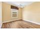 Cozy bedroom with wood floors, a ceiling fan, and a window offering natural light at 1123 Barnacle Ter, The Villages, FL 32162