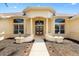 Elegant entryway featuring arched windows, stately columns, and a well-manicured garden bed at 1123 Barnacle Ter, The Villages, FL 32162