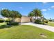 Beautiful exterior showcasing a well-maintained lawn, mature landscaping, and an attached two-car garage at 1123 Barnacle Ter, The Villages, FL 32162