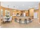 Modern kitchen with granite countertops, bar seating, and adjacent dining area with chandelier at 1123 Barnacle Ter, The Villages, FL 32162