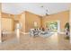 Bright living room with tile flooring, stylish furnishings, and a sliding glass door leading to the outdoors at 1123 Barnacle Ter, The Villages, FL 32162