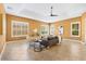 Bright living room featuring a tray ceiling, tile floors, and large windows with natural light at 1123 Barnacle Ter, The Villages, FL 32162