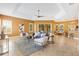 Spacious living room featuring tile flooring, large windows, and open access to the kitchen and breakfast nook at 1123 Barnacle Ter, The Villages, FL 32162