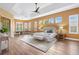 Bright and spacious main bedroom boasts tray ceilings, wood floors, and plantation shutters for added privacy at 1123 Barnacle Ter, The Villages, FL 32162